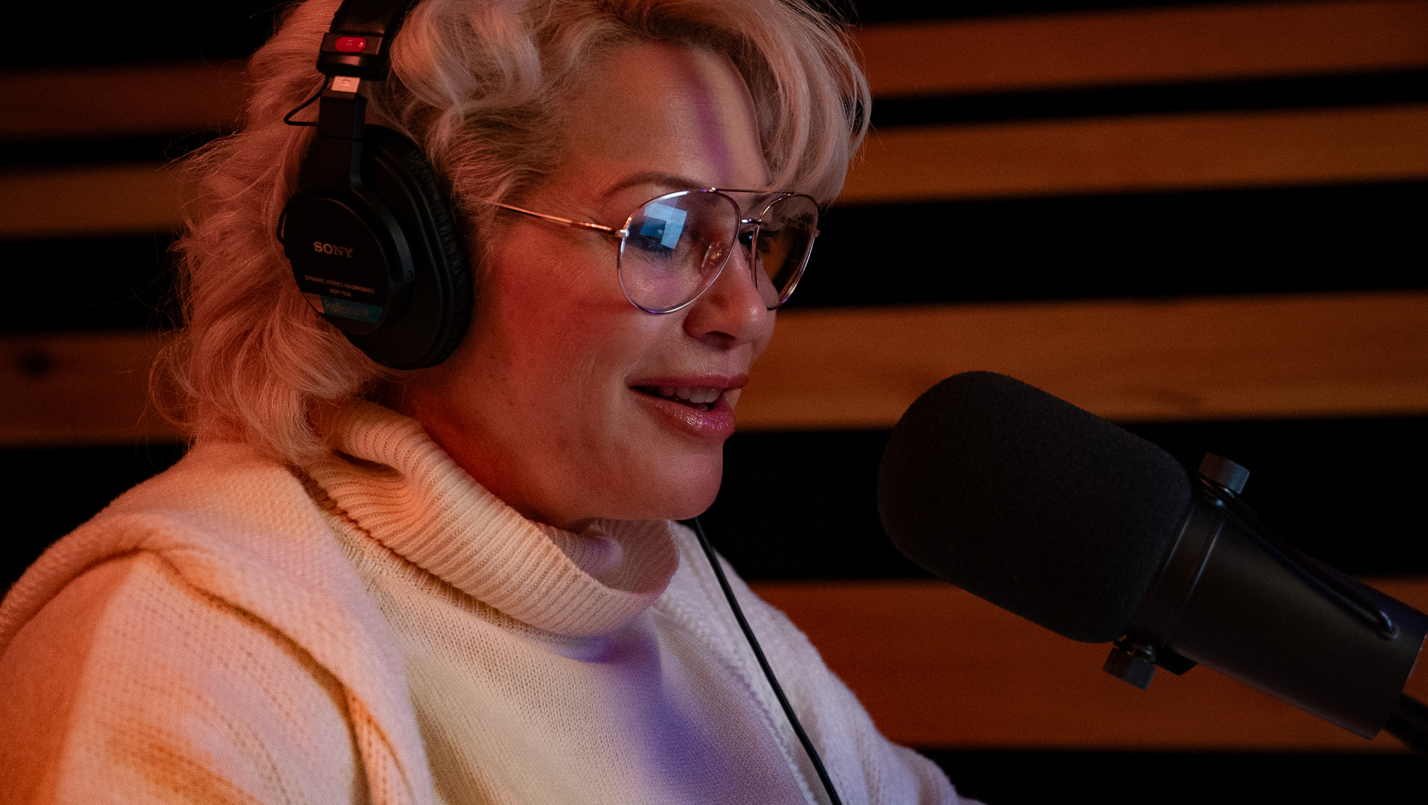Podcaster with glasses and Sony headphones at microphone